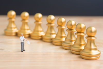 Close-up of chess pieces and figurine on table