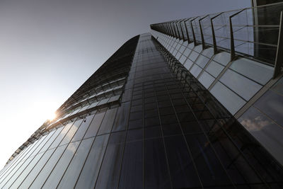 Low angle view of glass building against sky