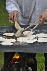 Close-up of man preparing food on barbecue grill