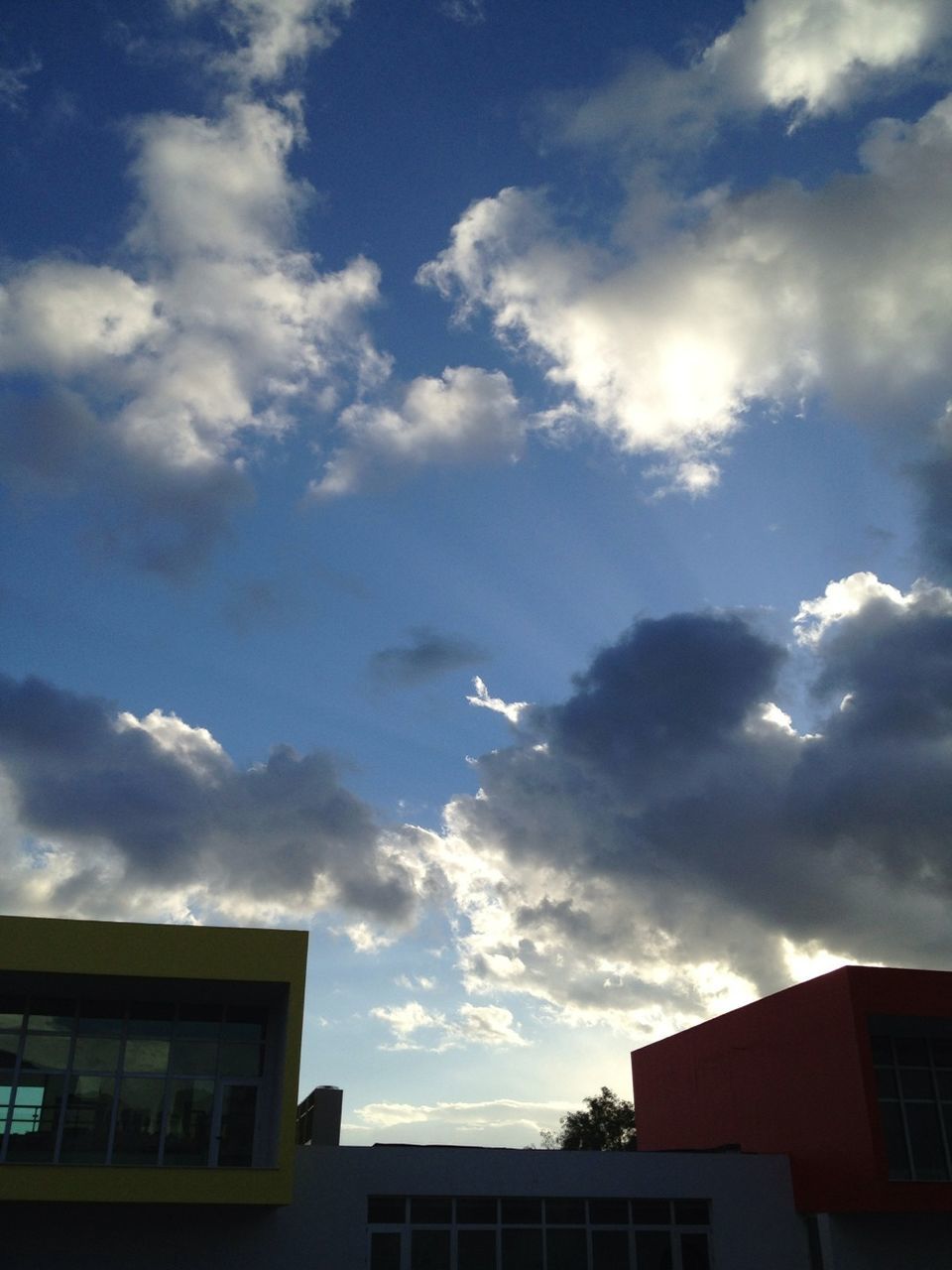 building exterior, architecture, built structure, sky, low angle view, cloud - sky, residential building, residential structure, cloud, house, cloudy, building, city, high section, blue, sunlight, outdoors, window, no people, nature