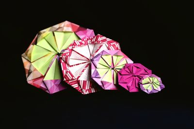 Close-up of multi colored umbrellas over black background