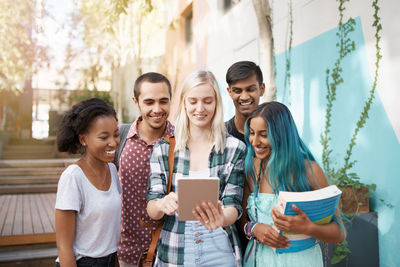 Cheerful friends talking on video call outdoors