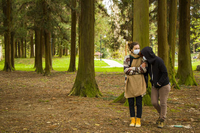 Two women friends in the park with face masks