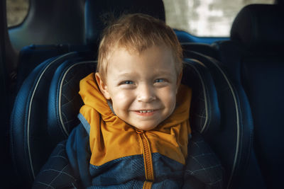 Close-up of smiling baby boy in car