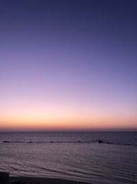 Scenic view of sea against clear sky at sunset