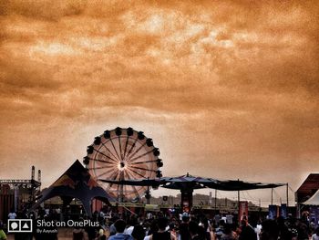 People in amusement park against sky
