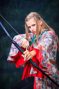 Portrait of teenage girl holding bow and arrow