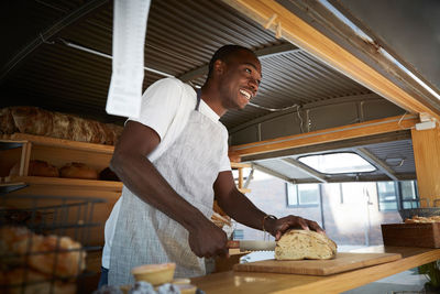 Side view of young man standing by food in store