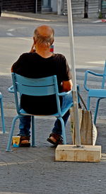 Rear view of man sitting on chair