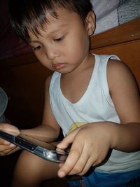 Boy looking away while sitting on mobile phone