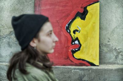 Portrait of senior woman against graffiti on wall