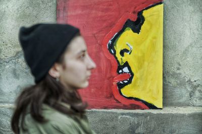 Portrait of senior woman against graffiti on wall