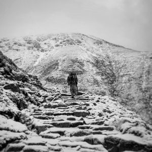 Rear view of man walking on mountain