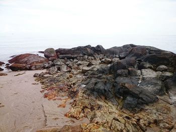 Rock formation on beach against sky