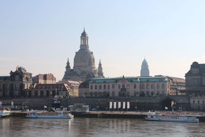 Boats in river with buildings in background