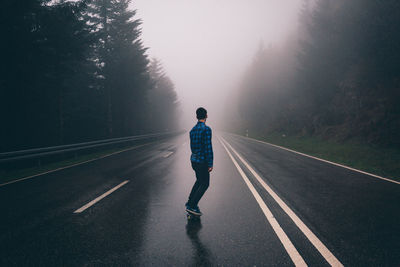 Full length of man skating on roller street during foggy weather