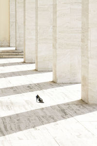 High angle view of abandoned high heels by colonnade