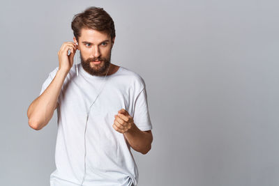 Portrait of young man standing against white background