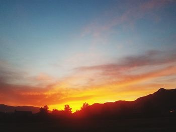Scenic view of dramatic sky over silhouette landscape