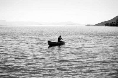 Man in boat on sea against sky