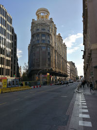 City street and buildings against sky