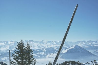 Pole against snowcapped mountains