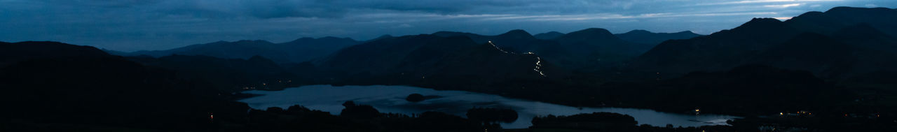 Scenic view of silhouette mountains against sky at night