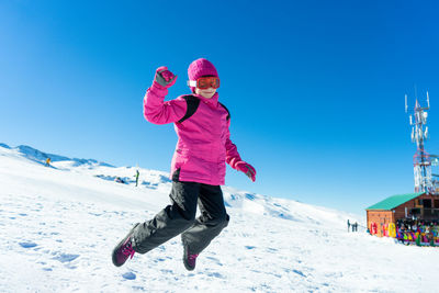 Full length of girl on snow covered landscape against sky