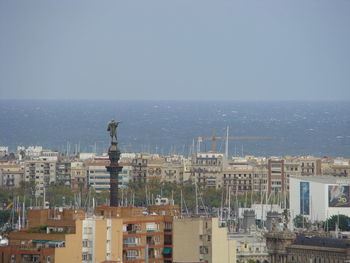 High angle view of buildings by sea against sky