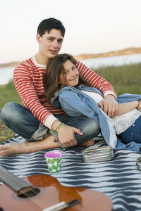 Portrait of smiling couple enjoying picnic in field