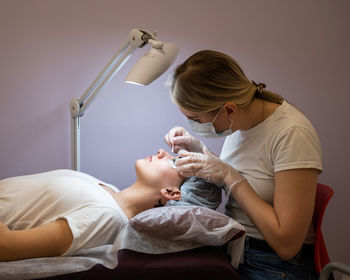 Beautician treating patient at spa