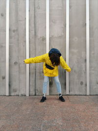 Full length of girl standing on yellow umbrella