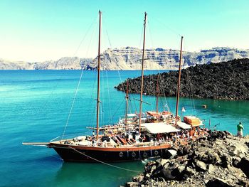 Sailboats moored in sea against sky