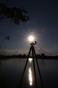 Sun shining over lake during sunset