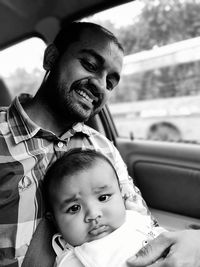 Portrait of father and daughter sitting in car