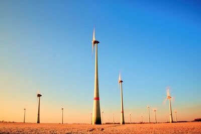 Wind turbines producing electric energy within sunny spring morning. vintage style toned effect