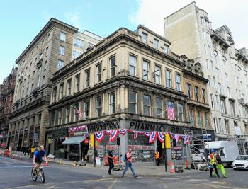 People on street against buildings in city