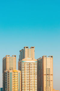 Low angle view of modern buildings against clear blue sky