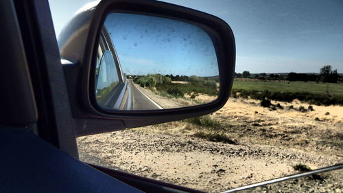 Reflection of road on side-view mirror of car