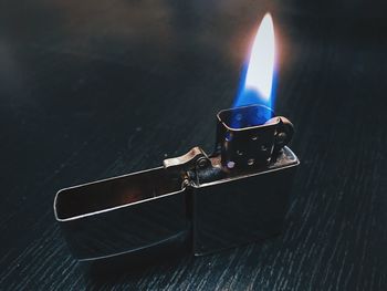 High angle view of burning candle on table