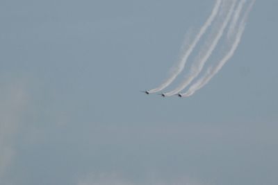 Low angle view of airplane flying against clear blue sky