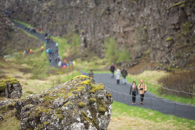 People on rock by mountain