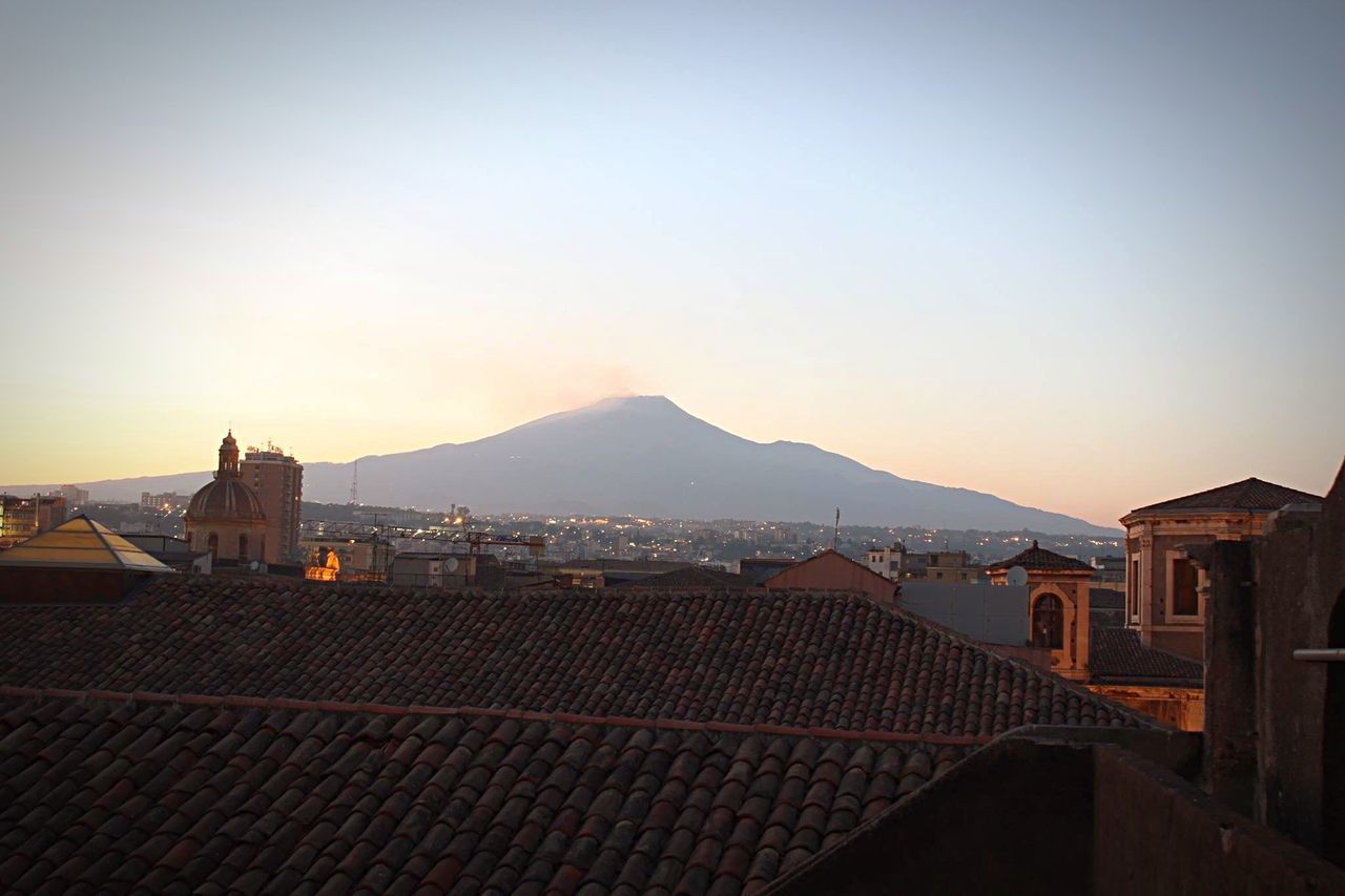 built structure, architecture, mountain, mountain range, sunset, roof, scenics, landscape, tranquility, sky, tranquil scene, beauty in nature, nature, outdoors, travel destinations, no people, town, cityscape, idyllic, horizon over land, hill, tourism, townscape, residential district, blue