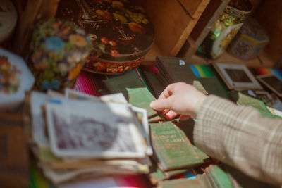 Cropped image of hand taking religious book at market