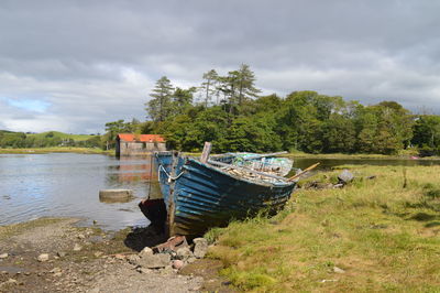 Boat moored on shore against sky