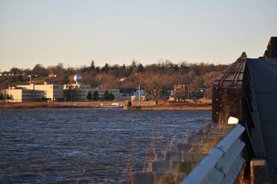 Houses by sea against clear sky