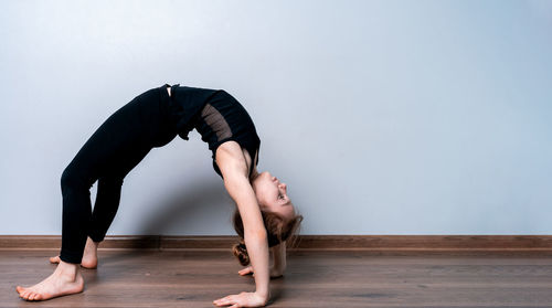 Woman looking away while sitting on hardwood floor