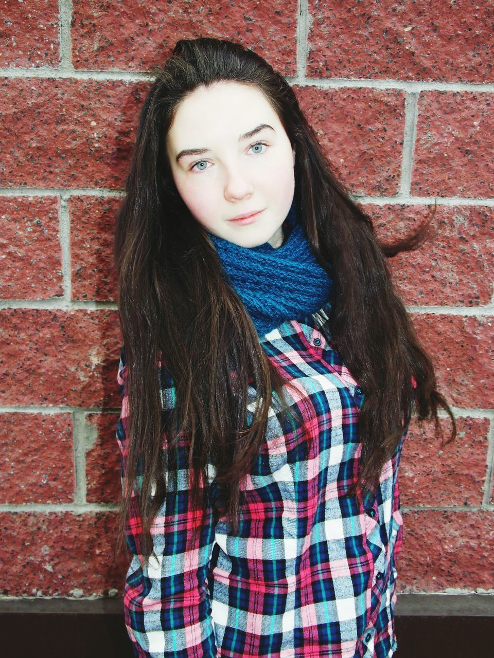 person, portrait, looking at camera, casual clothing, front view, lifestyles, young adult, young women, brick wall, standing, wall - building feature, smiling, leisure activity, long hair, three quarter length, waist up, happiness