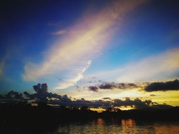 Silhouette trees by lake against sky during sunset