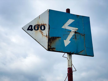 Low angle view of road sign against sky